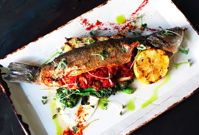 Signature Branzino with sugo puttanesca, spiced rapini, grilled house-made focaccia | Image courtesy of Lake Road Restaurant