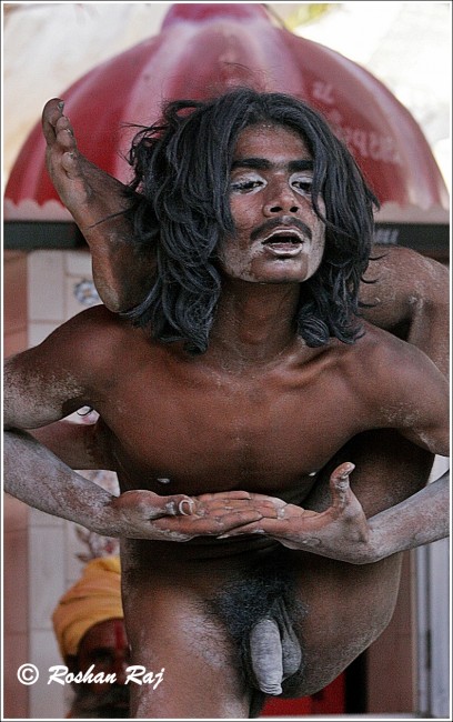 Naga Sadhu assuming a yoga pose for the photographer |© Flickr/Roshan Raj