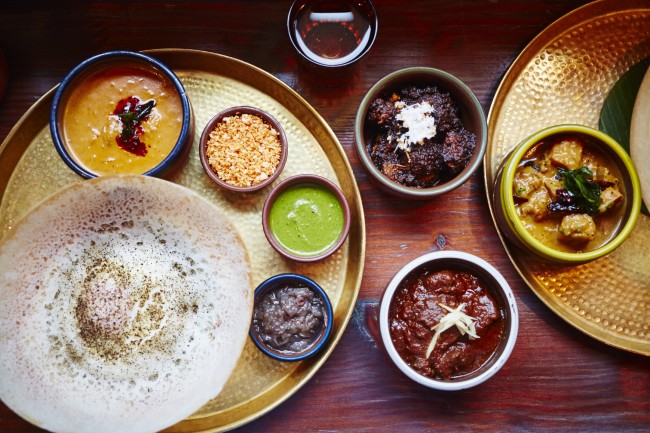 Fish Kari, Black Pork Kari, Lamb Kari and Red Pumpkin Kari with Pol Sambol, Seeni Sambol, Coriander Chutney on plate | © David Loftus