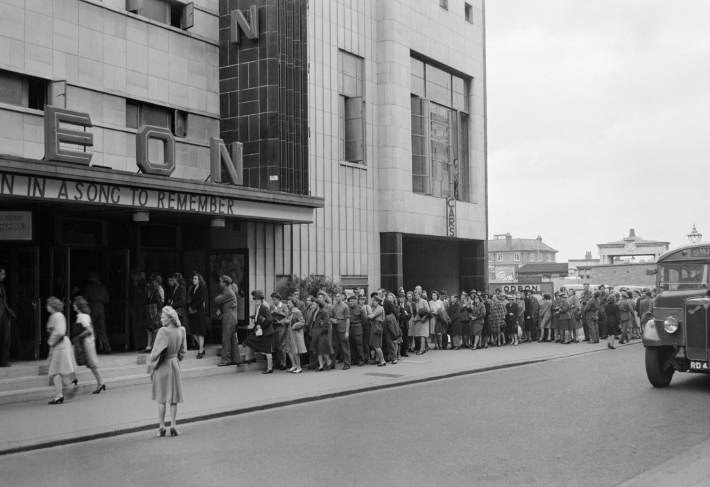 A long queue stretches out from the entrance of the Odeon Cinema in wartime Reading, as people buy tickets, 1945|©© IWM (D 25326) /IWM