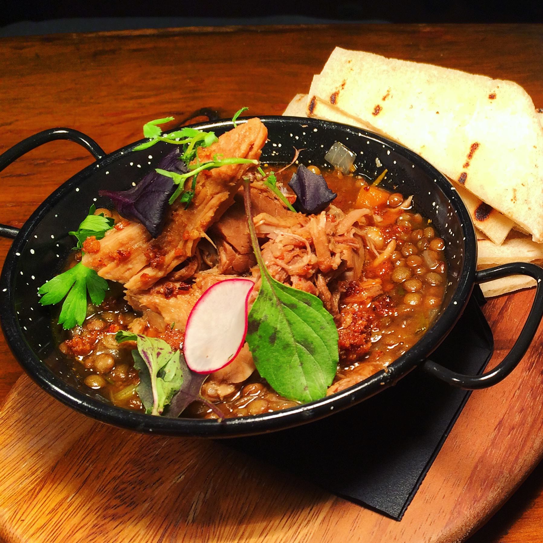 Slow roasted pork leg & braised lentils | Courtesy of Habitué