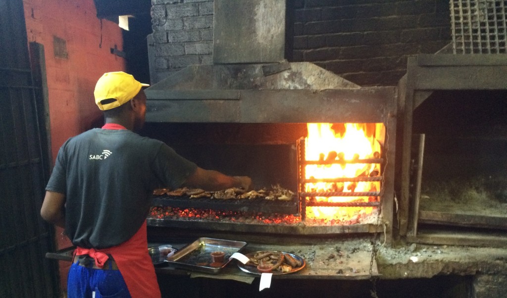 A staff member at Mzoli's Place braais meat for patrons in Gugulethu township © Jonathan Khoo/Flickr