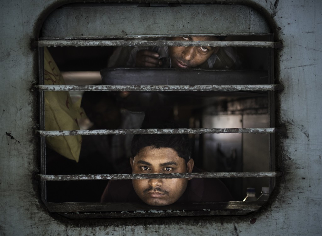 Marco Pozzi, Men peering out from a train, Jaipur, India