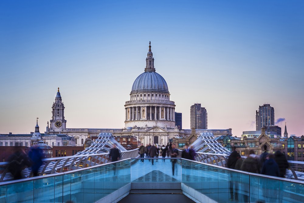Londoners walking through Millennium Bridge with St.Paul's Cathedral at the background after sunset - London, UK |© Zoltan Gabor/Shutterstock