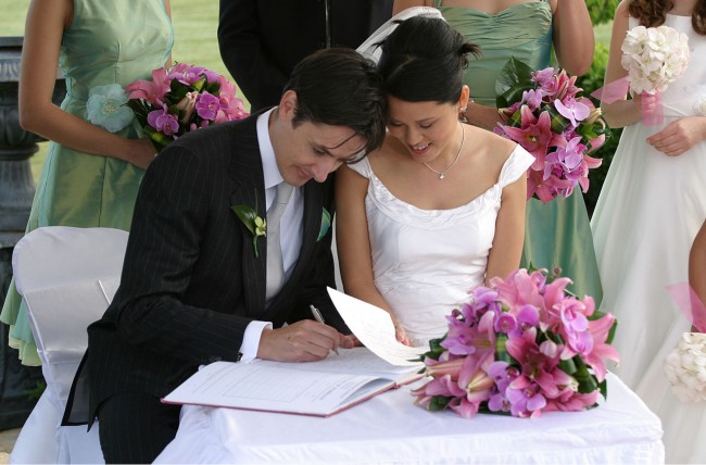 Wedding signatures | ©Jason Hutchens / Wikimedia https://commons.wikimedia.org/wiki/File:Bride_and_groom_signing_the_book.jpg