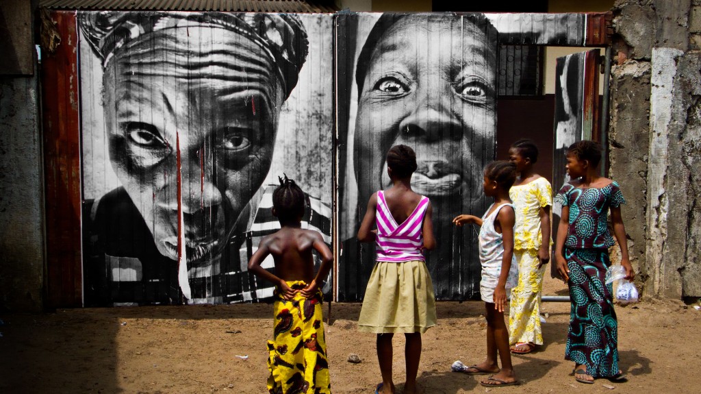“28 Millimètres : Women Are Heroes, Pasting in Monrovia streets, Liberia” © JR-ART.NET / Courtesy Gallerie Perrotin