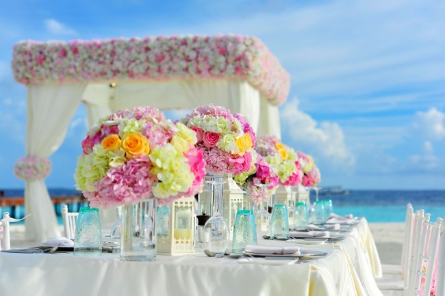 Beach reception | © Ibrahim Asad / Pexels https://www.pexels.com/photo/yellow-and-pink-petaled-flowers-on-table-near-ocean-under-blue-sky-at-daytime-169193/