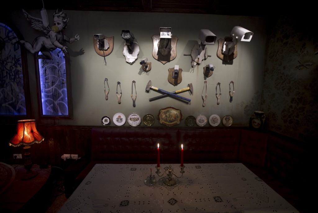 Wall decorated with security cameras and slingshots is seen in the bar area of the "The Walled Off Hotel" and the Israeli security barrier in the West Bank city of Bethlehem | Photo by AP/REX/Shutterstock (8467370c) Wall decorated with security cameras and slingshots is seen in the bar area of the "The Walled Off Hotel" and the Israeli security barrier in the West Bank city of Bethlehem, . The owner of a guest house packed with the elusive artist Banksy's work has opened the doors of his West Bank establishments to media, showcasing its unique "worst view in the world." The nine-room hotel named "The Walled Off Hotel" will officially open on March 11 Palestinians Banksy - 03 Mar 2017