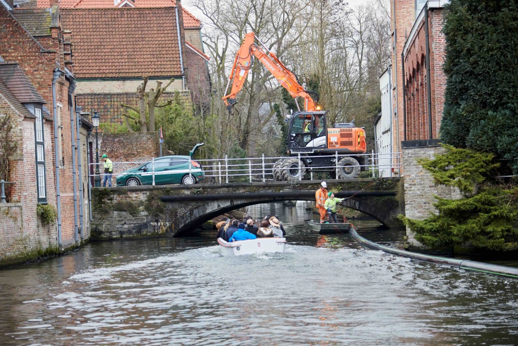 A boatload of tourists getting a front row seat to the installation of Bruges' unique pipeline | courtesy of De Halve Maan