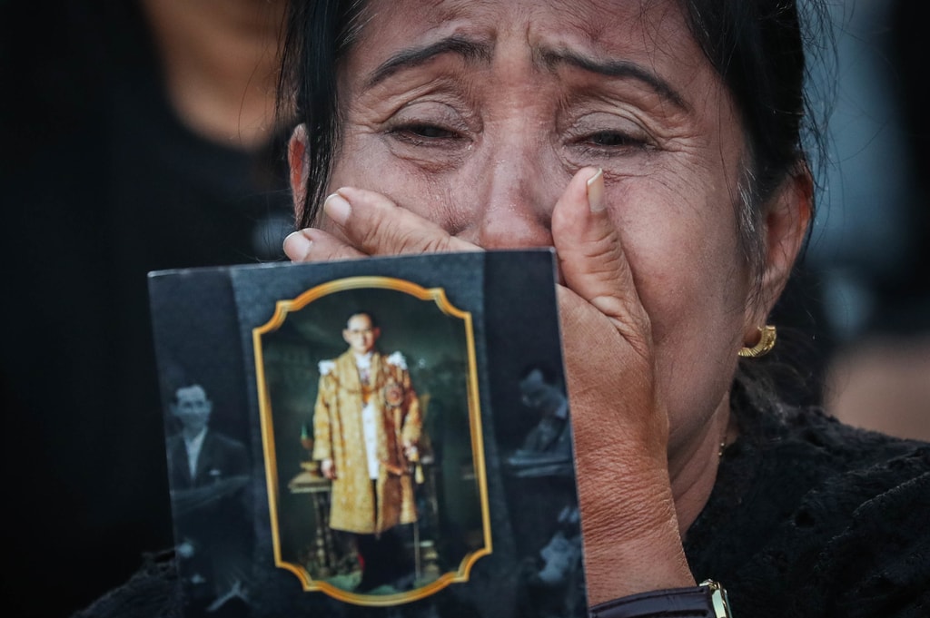 A mourner in tears presents a picture of the late king during the ceremony | © Diego Azubel/EPA-EFE/REX/Shutterstock