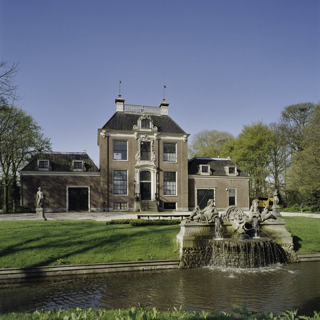 Overzicht_voorzijde_ingangspartij_met_deuromlijsting_en_op_de_voorgrond_een_fontein_met_beelden_-_Amsterdam_-_20409094_-_RCE
