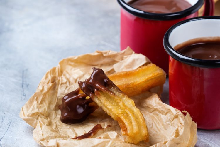 Traditional spanish churros with hot chocolate in a mug