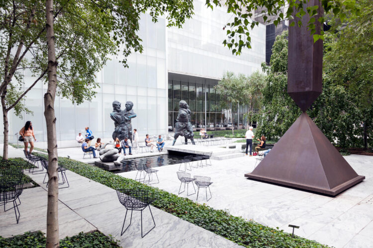 visitors sit and walk in sculpture garden of moma new york city