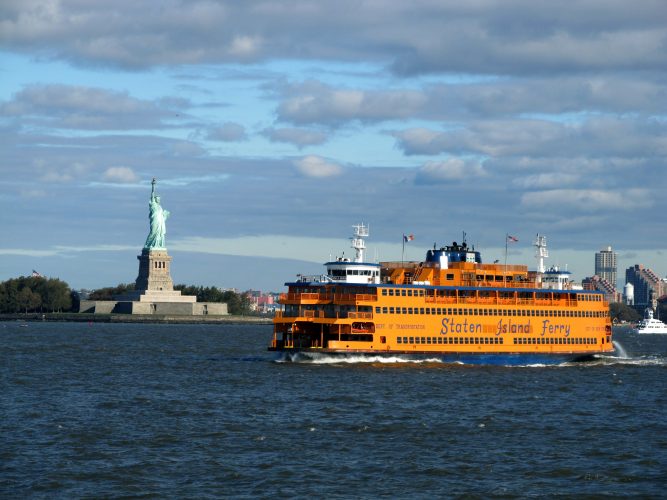 Staten Island Ferry passes the Statue of Liberty on its way from New York to Staten Island, which passengers can ride the ferry for free.