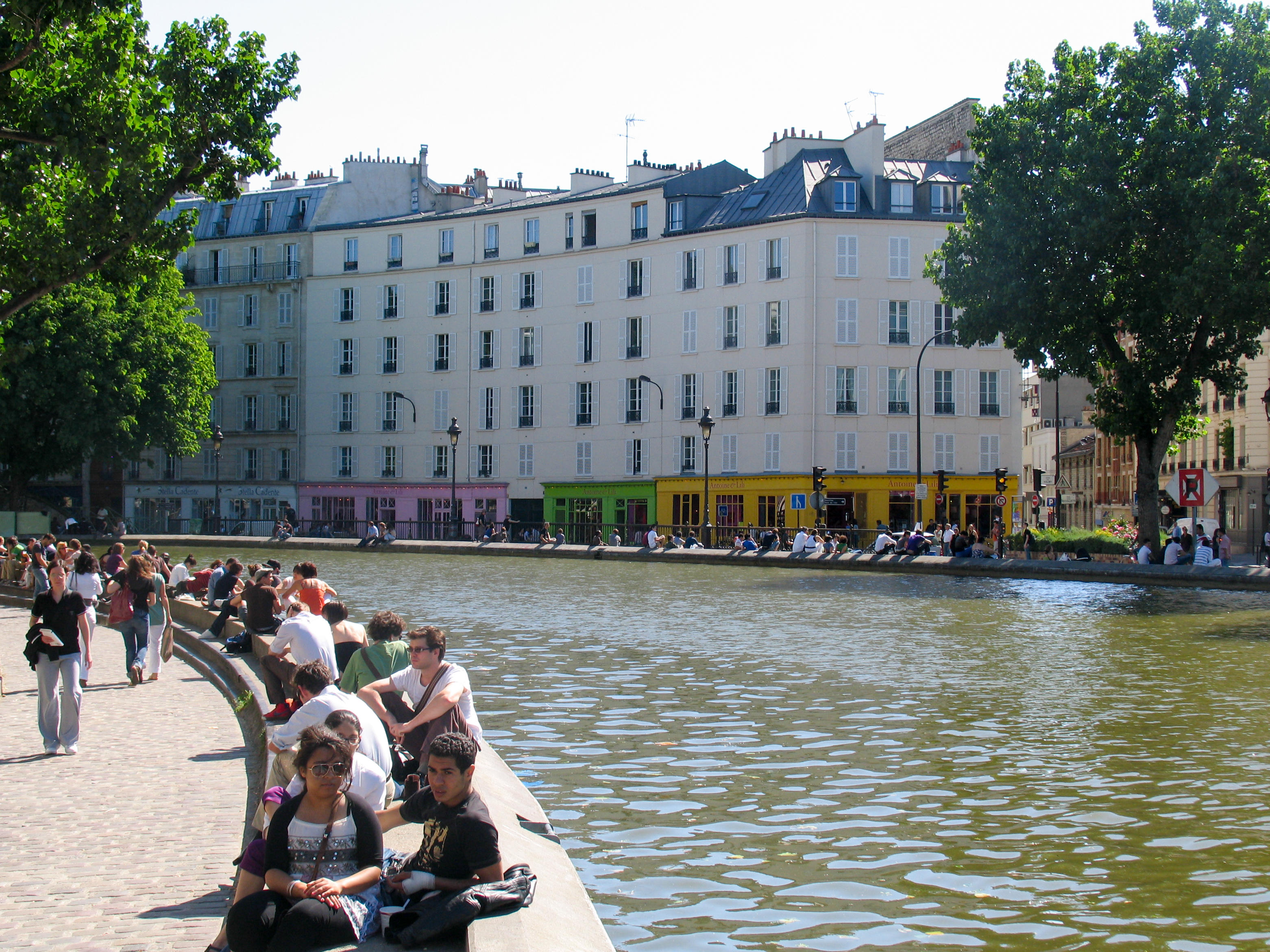 People sitting and enjoying the spring sun along Canal Saint-Martin, Paris.