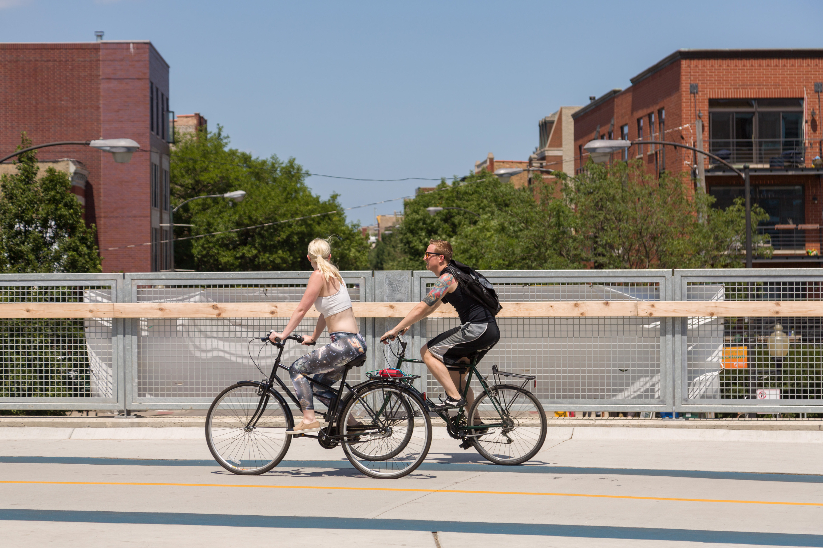 Bicyclists along the 606 elevated bike trail, green space and park built on the old Bloomingdale Line in the Wicker Park neighborhood in Chicago, Illinois, USA