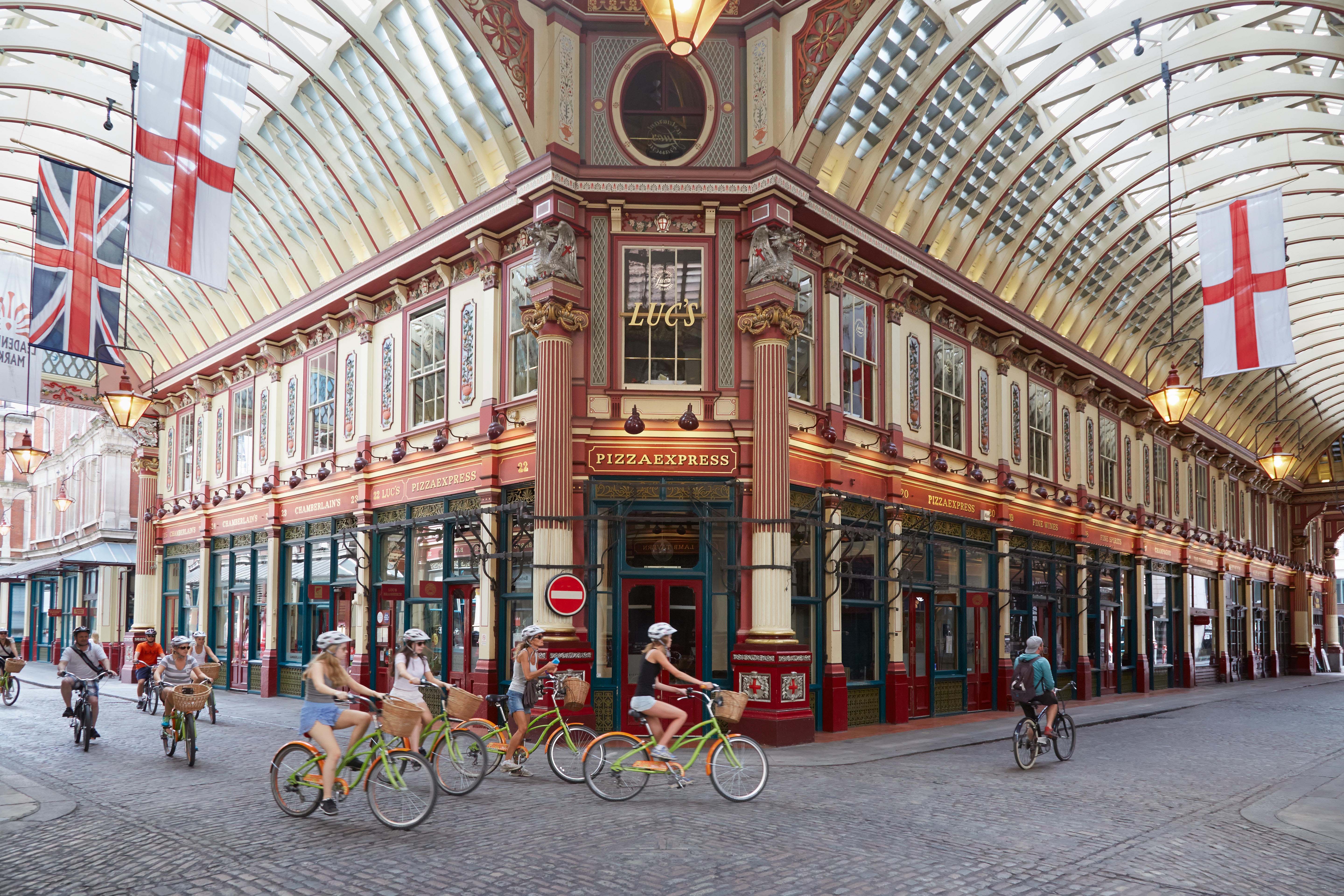 Leadenhall covered market interior with tourists in bicycle in a summer afternoon in London