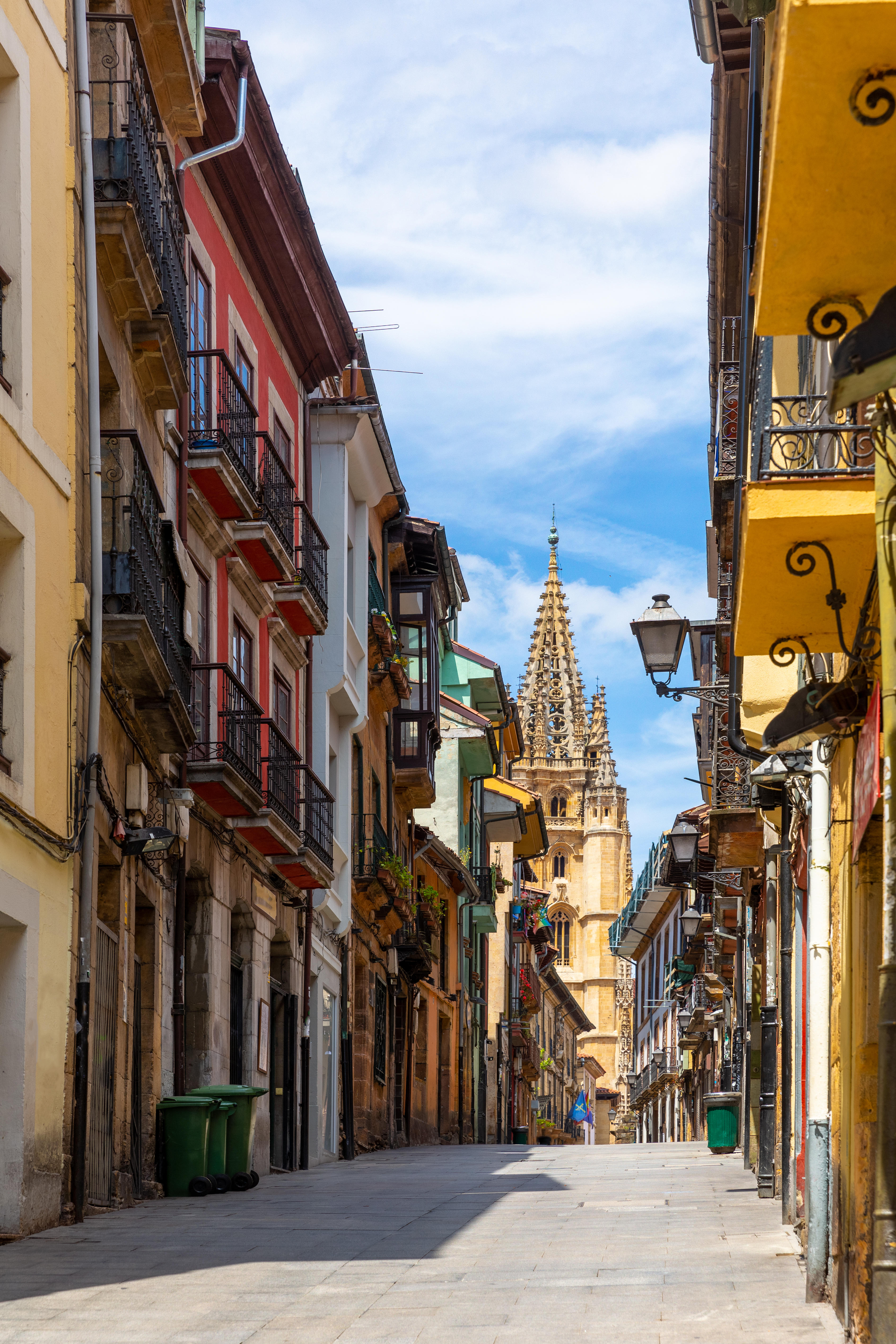 View of old narrow street of Oviedo city leading to Gothic Cathedral of San Salvador on sunny summer day, Asturias, Spain